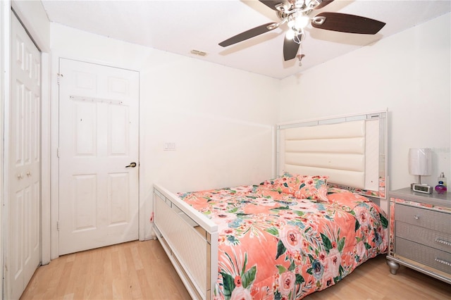 bedroom with ceiling fan, light hardwood / wood-style floors, and a closet