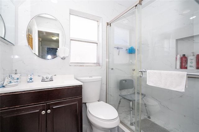 bathroom featuring vanity, a shower with shower door, and toilet