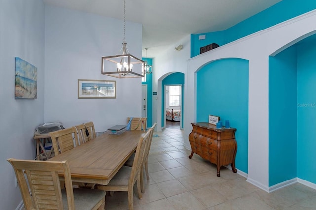 tiled dining area with lofted ceiling and a notable chandelier