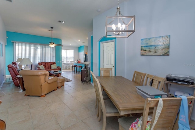 tiled dining space featuring ceiling fan with notable chandelier