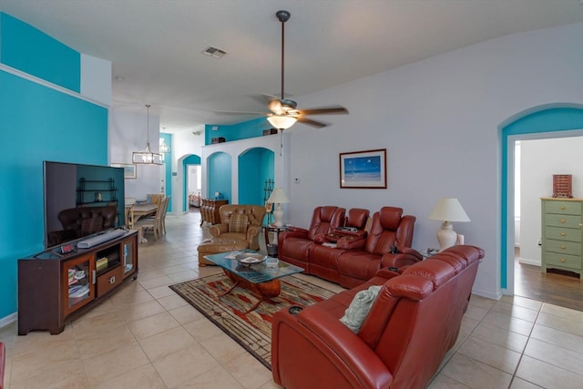 tiled living room featuring ceiling fan with notable chandelier