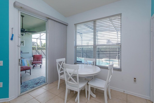 tiled dining area with ceiling fan and vaulted ceiling