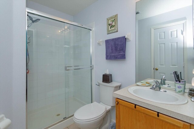 bathroom with an enclosed shower, vanity, and toilet