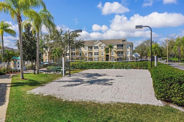 view of property's community featuring volleyball court and a lawn