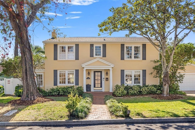 colonial home featuring a front lawn