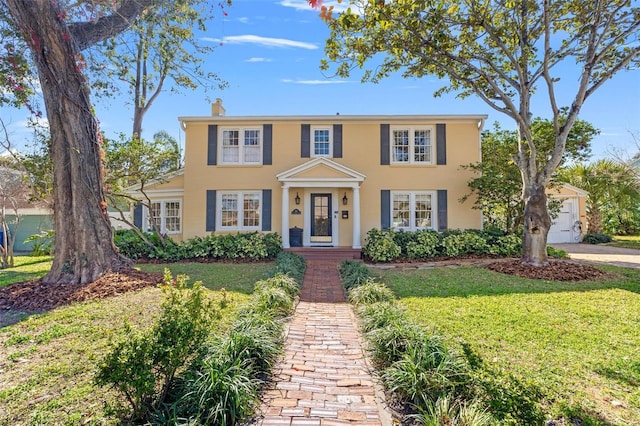 colonial home featuring a front lawn