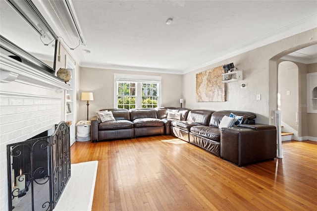 living room with hardwood / wood-style floors, a fireplace, and ornamental molding