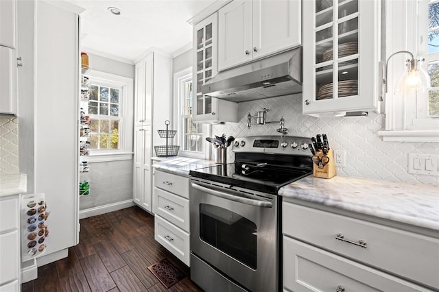 kitchen featuring white cabinetry, dark hardwood / wood-style floors, tasteful backsplash, ornamental molding, and stainless steel electric stove