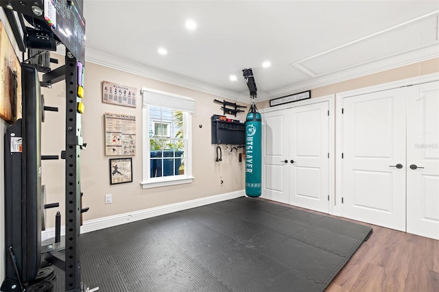 exercise room featuring ornamental molding and dark wood-type flooring