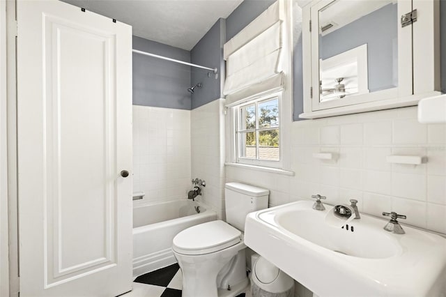 full bathroom with tiled shower / bath combo, sink, tile walls, and toilet