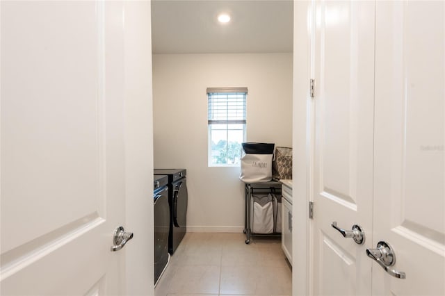 laundry area with light tile patterned floors and washer and clothes dryer