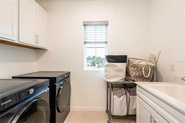 laundry room featuring cabinets, sink, light tile patterned floors, and washing machine and clothes dryer