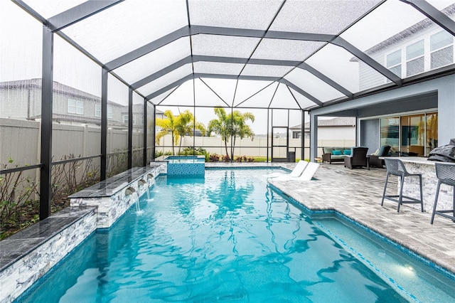 view of swimming pool with a lanai, a patio, exterior bar, pool water feature, and an in ground hot tub