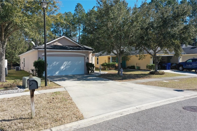 single story home featuring a garage, a front yard, and central air condition unit