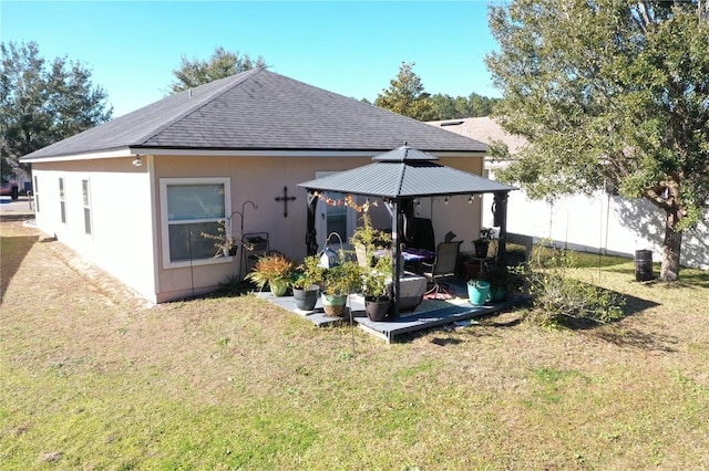 back of house featuring a gazebo and a lawn