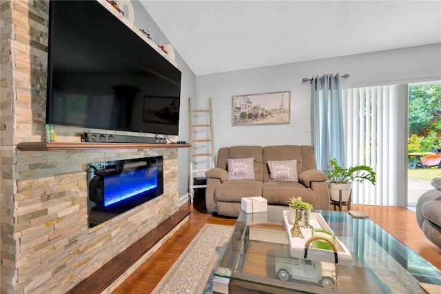 living room with hardwood / wood-style flooring, lofted ceiling, and a fireplace