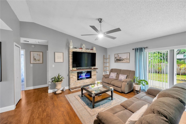 living room with a fireplace, vaulted ceiling, hardwood / wood-style floors, and a textured ceiling