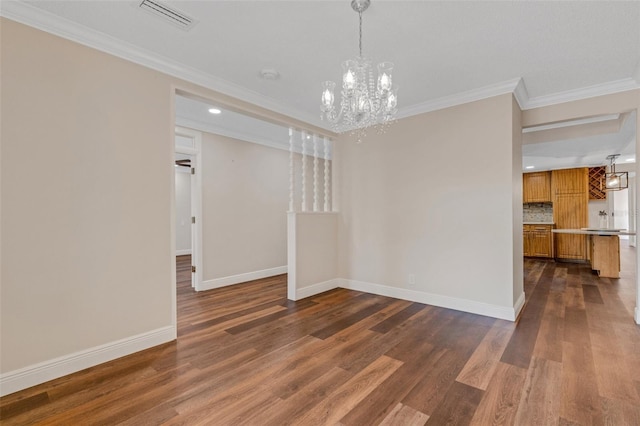 spare room with a notable chandelier, crown molding, and dark hardwood / wood-style floors