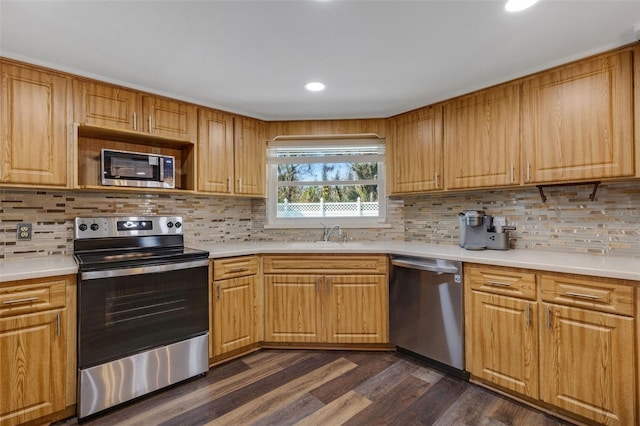 kitchen with dark hardwood / wood-style flooring, sink, decorative backsplash, and appliances with stainless steel finishes