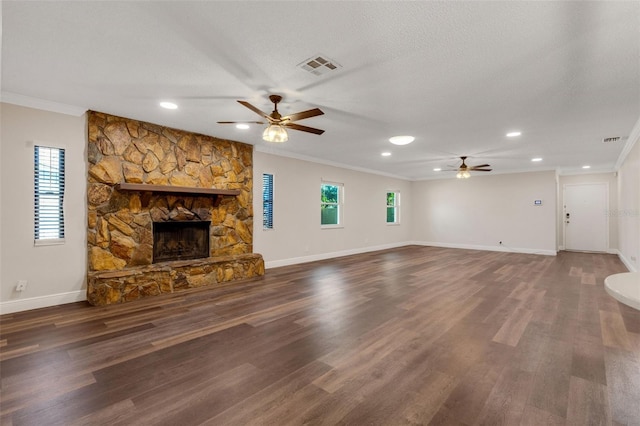 unfurnished living room featuring dark hardwood / wood-style floors, a stone fireplace, and crown molding