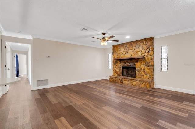 unfurnished living room with a fireplace, wood-type flooring, ornamental molding, ceiling fan, and a textured ceiling