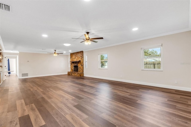 unfurnished living room featuring dark wood-type flooring, a fireplace, ornamental molding, and ceiling fan