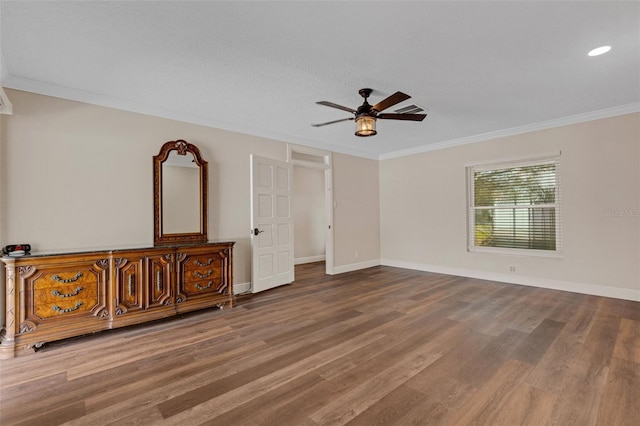 unfurnished bedroom featuring hardwood / wood-style flooring, ornamental molding, and ceiling fan