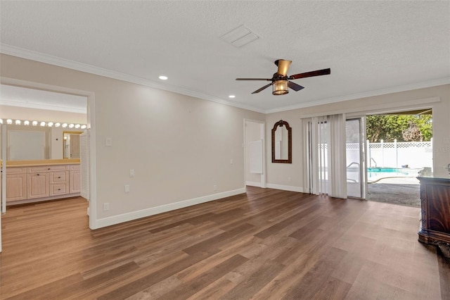 unfurnished living room with hardwood / wood-style floors, crown molding, a textured ceiling, and ceiling fan