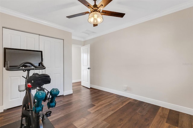 exercise area featuring dark wood-type flooring, ornamental molding, and ceiling fan