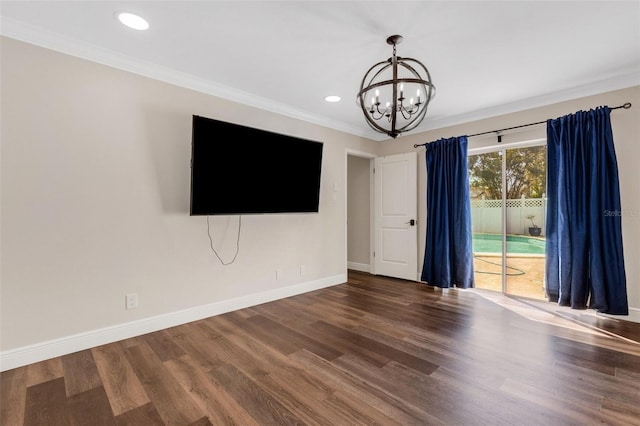 unfurnished living room with an inviting chandelier, ornamental molding, and hardwood / wood-style flooring