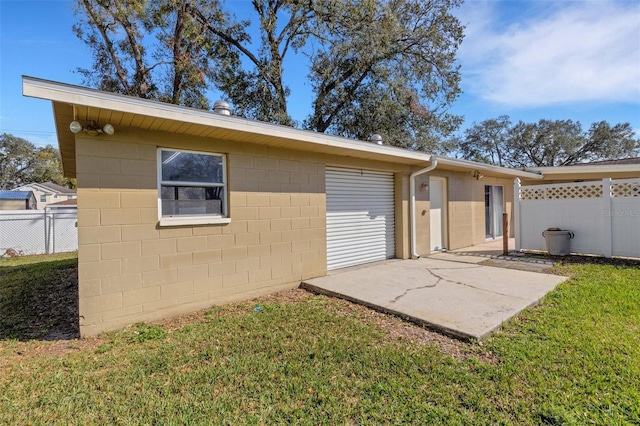 back of house featuring a patio and a lawn