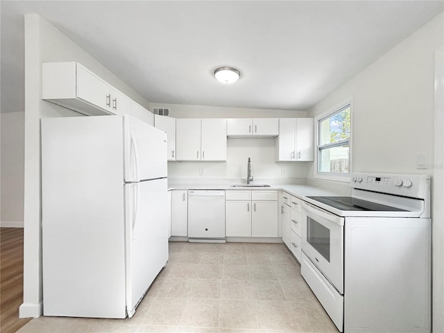 kitchen with white cabinetry, sink, and white appliances