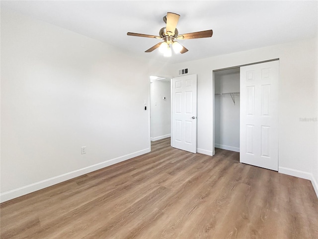 unfurnished bedroom with hardwood / wood-style flooring, ceiling fan, and a closet