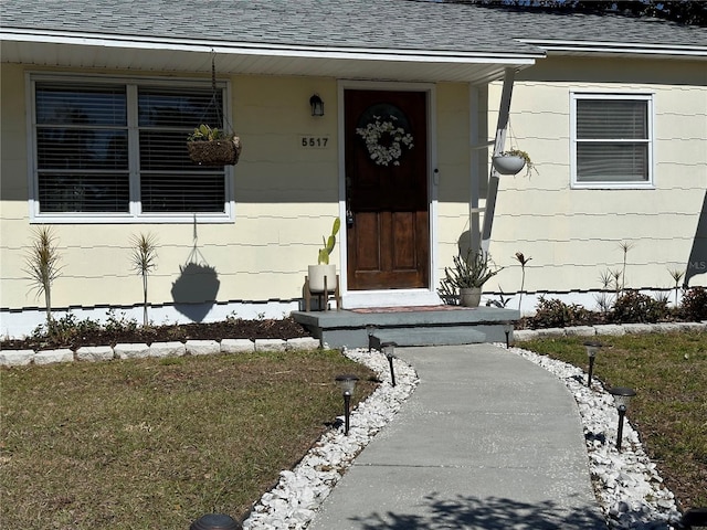 view of exterior entry with a yard