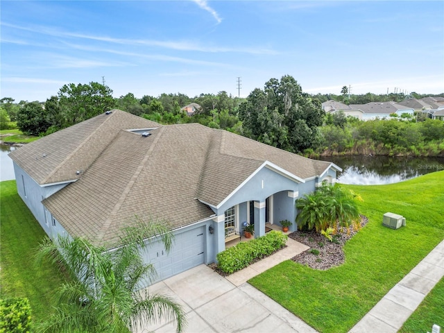 view of front of house featuring a garage, a water view, a porch, and a front yard