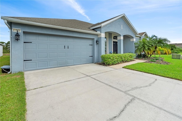 ranch-style home with a garage and a front lawn