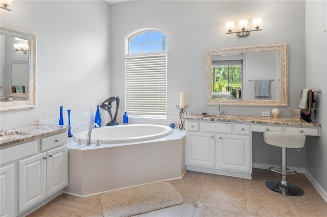 bathroom featuring tile patterned flooring, vanity, and tiled bath