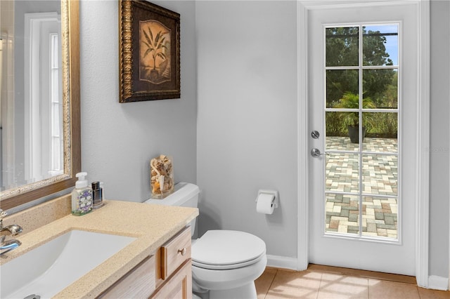 bathroom with tile patterned flooring, vanity, and toilet