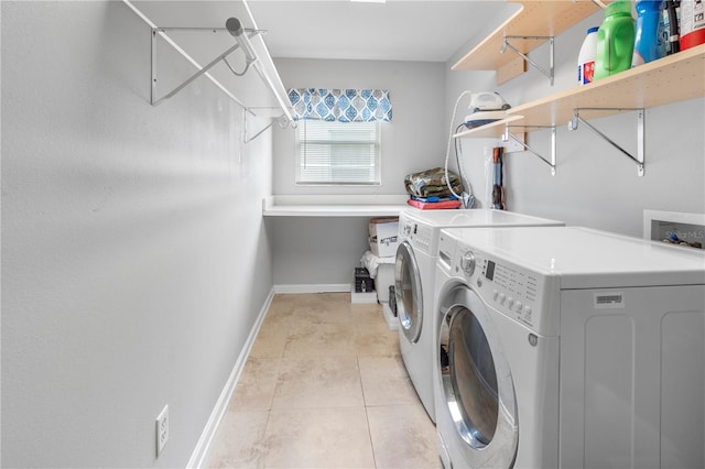 laundry area featuring light tile patterned floors and washer and clothes dryer