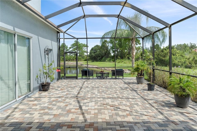 view of patio with a water view and a lanai