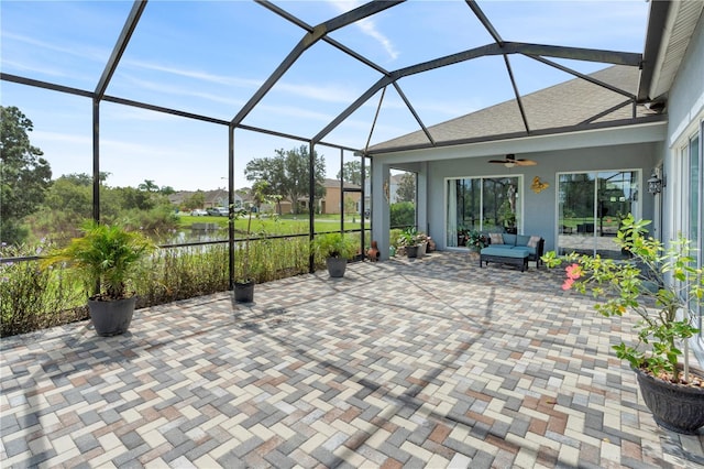 view of patio / terrace featuring an outdoor living space, ceiling fan, and glass enclosure