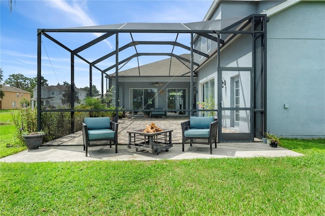 rear view of property with a fire pit, a yard, a lanai, and ceiling fan