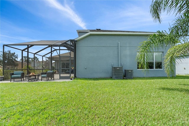 back of property with a patio, a yard, and glass enclosure