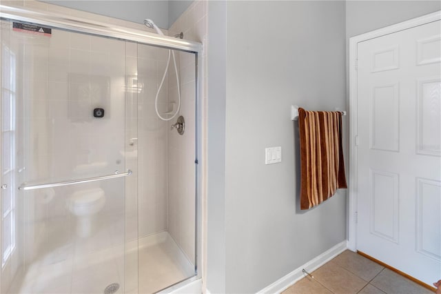 bathroom featuring tile patterned floors and a shower with shower door