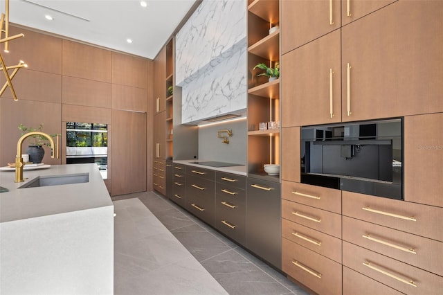 kitchen with double oven, sink, black electric stovetop, light brown cabinets, and built in shelves