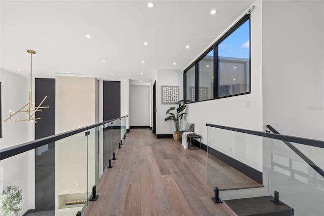 workout area featuring an inviting chandelier, light hardwood / wood-style floors, and expansive windows