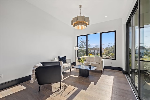 living room with dark hardwood / wood-style flooring and a notable chandelier