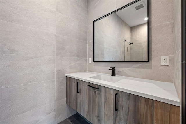 bathroom featuring vanity and tile walls