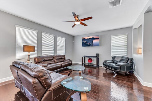 living room featuring dark wood-type flooring and ceiling fan