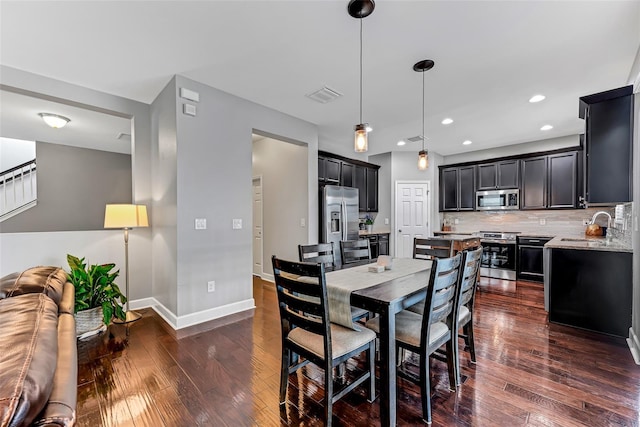 dining space with dark hardwood / wood-style floors and sink